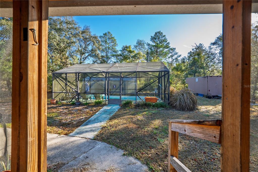 15321 Northeast 160th Avenue Road Salt Springs, FL 32134 - Photo 12 of 22 a backyard of a house with table and chairs potted plants with wooden floor