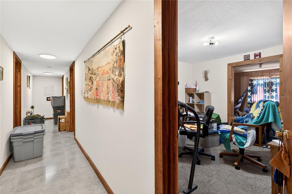 15321 Northeast 160th Avenue Road Salt Springs, FL 32134 - Photo 9 of 22 a view of a hallway with workspace and livingroom with furniture