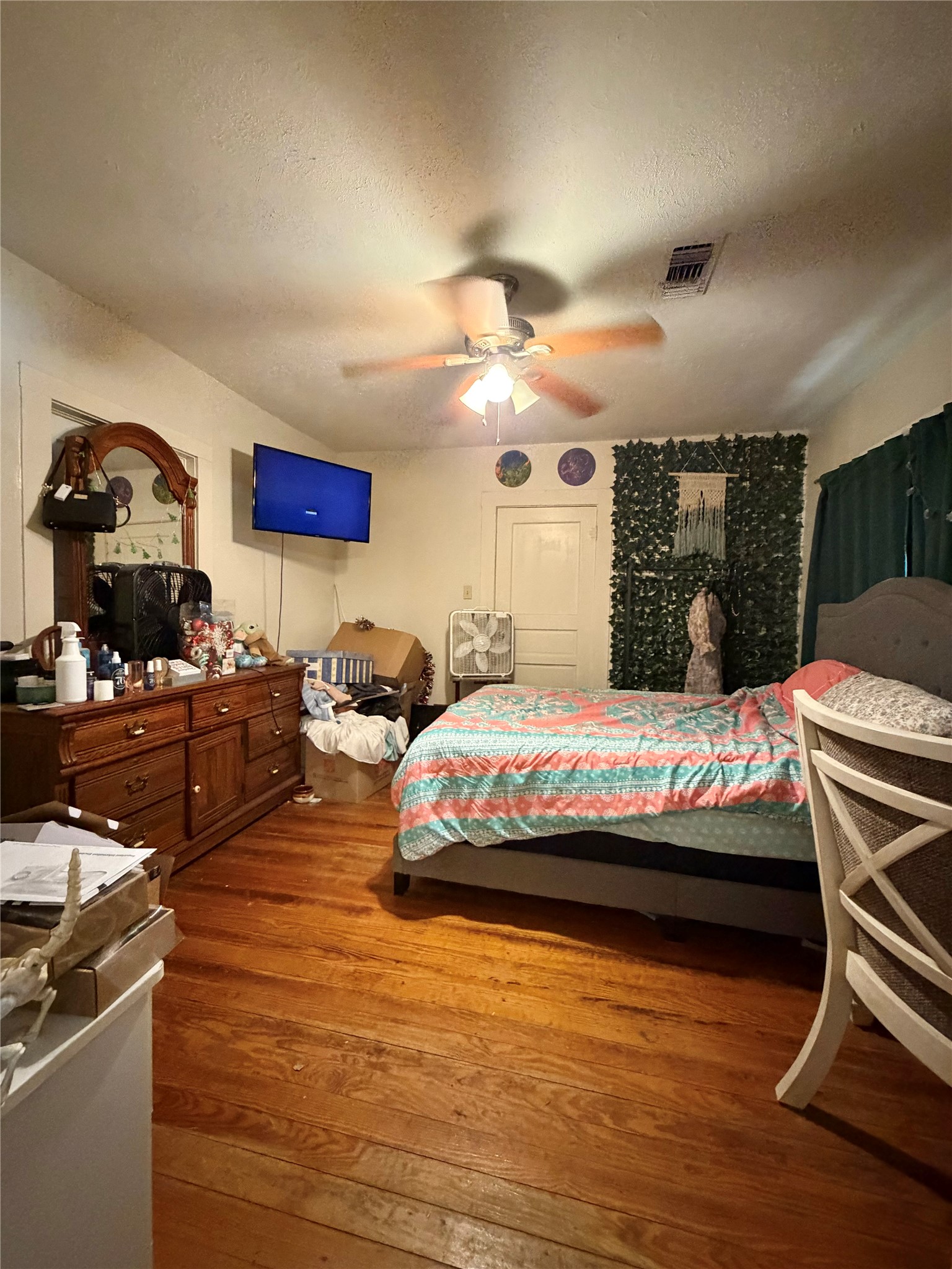 326 West 2nd Street Freeport, TX 77541 - Photo 18 of 24 a spacious bedroom with a bed a table and potted plants on the wooden floor