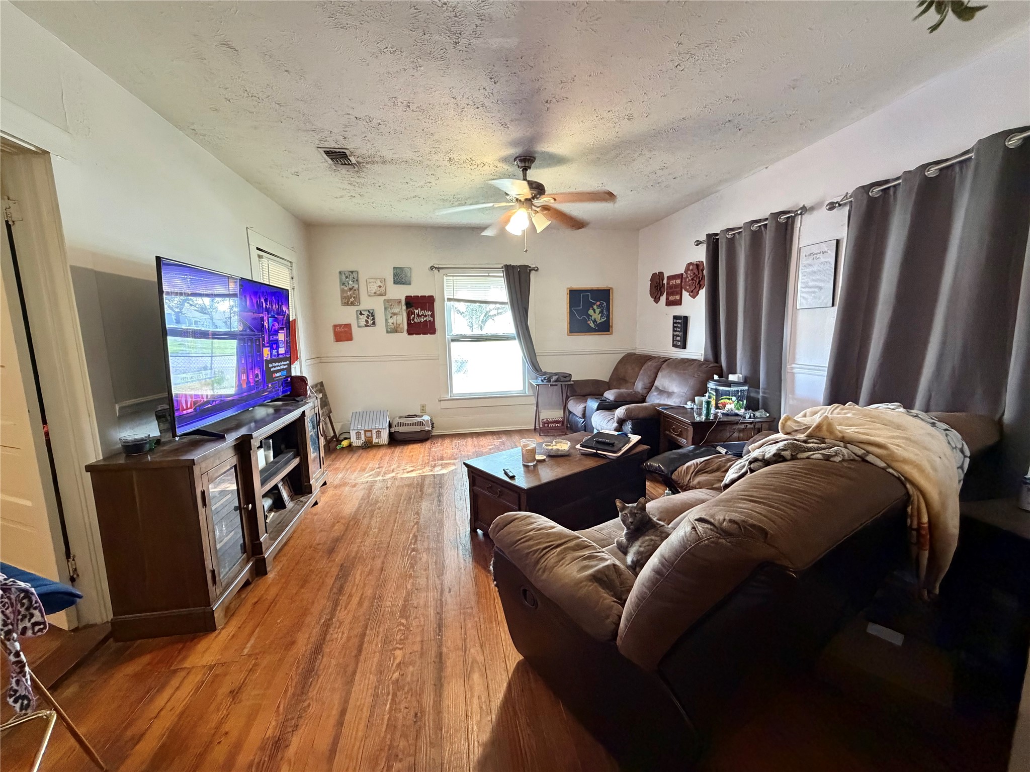 326 West 2nd Street Freeport, TX 77541 - Photo 7 of 24 a living room with furniture a flat screen tv and a refrigerator