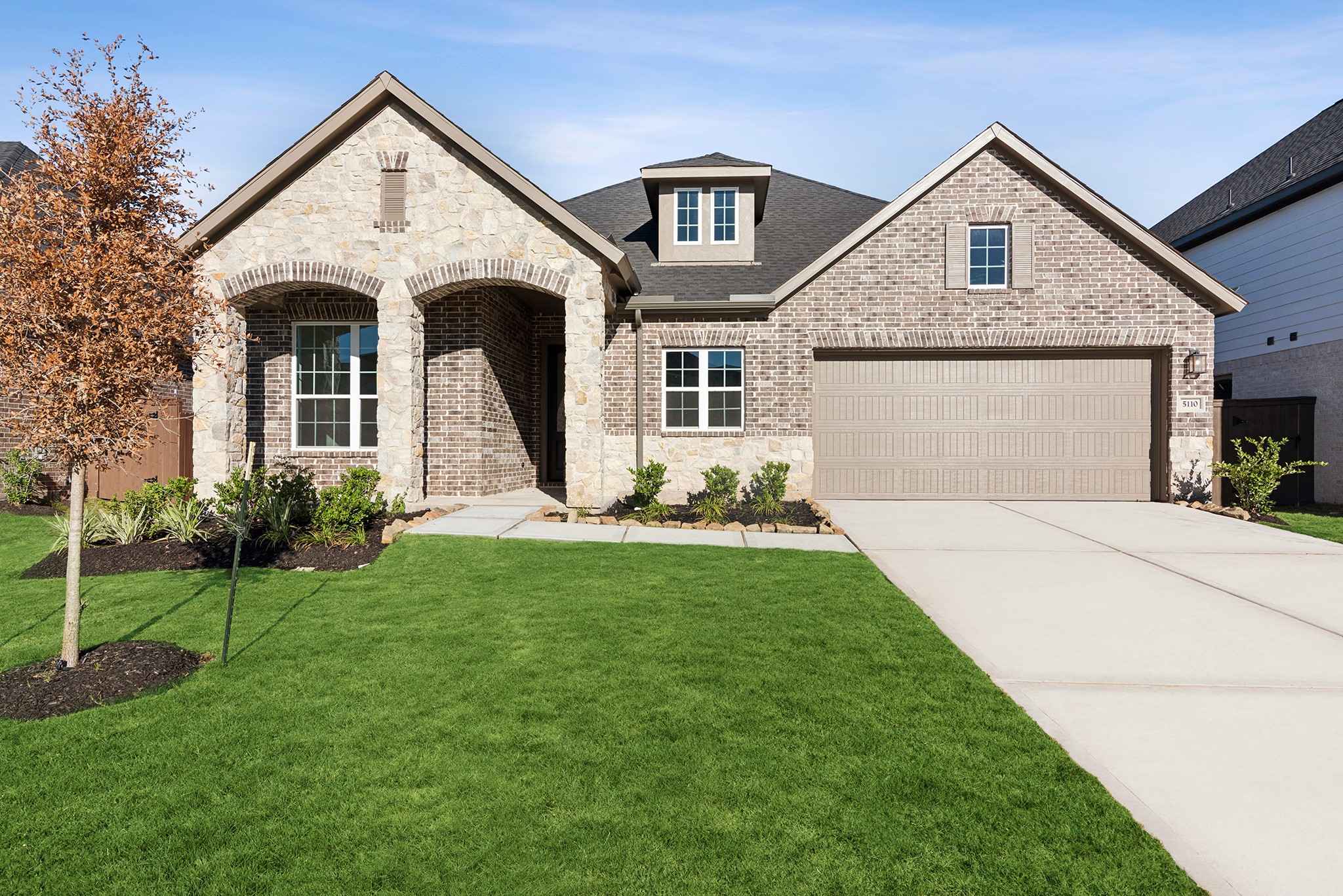 a front view of a house with a yard and garage