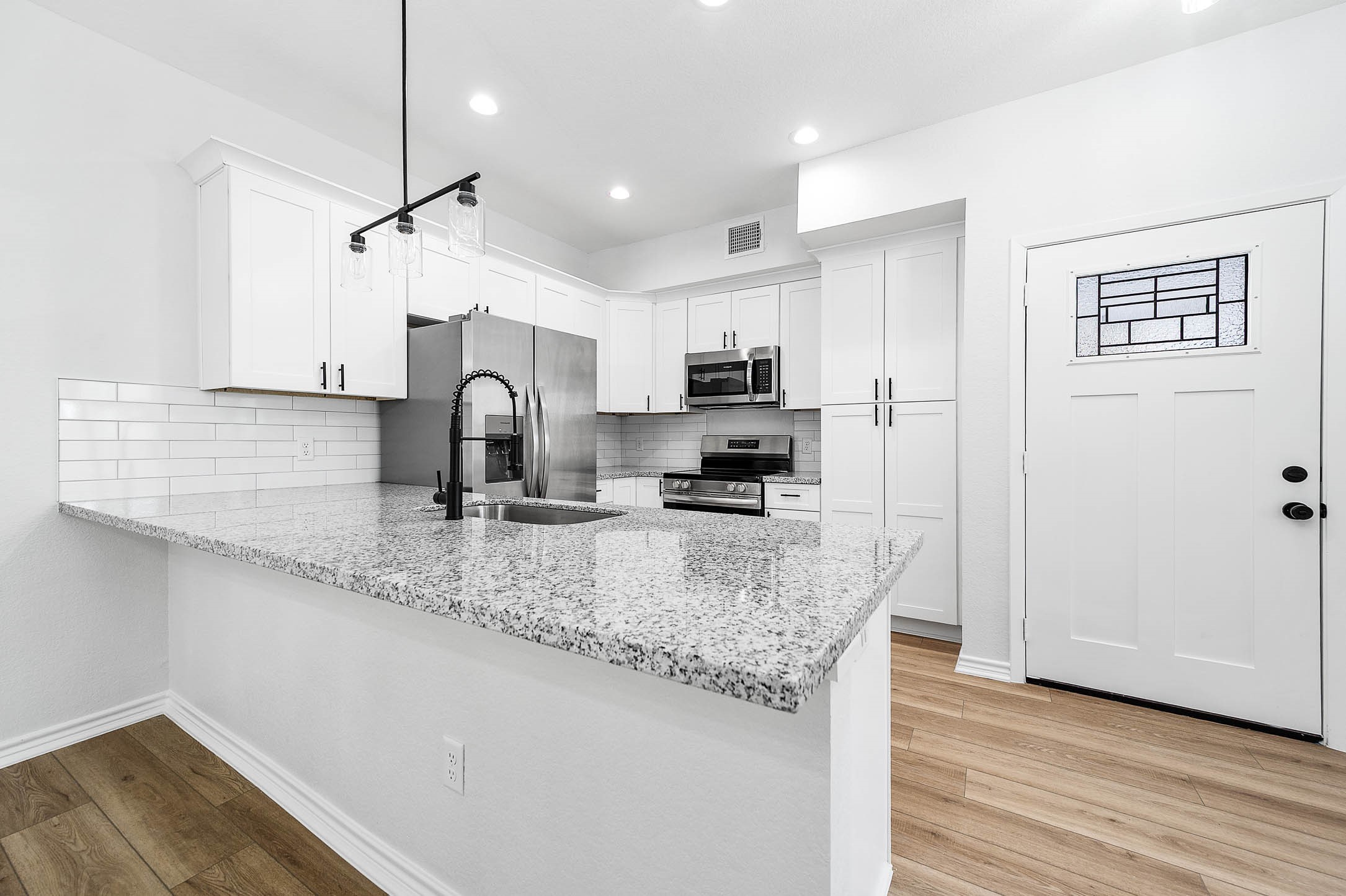 2024 Hampton Street, Unit A B Houston, TX 77088 - Photo 8 of 31 a kitchen with kitchen island granite countertop a sink cabinets and wooden floor