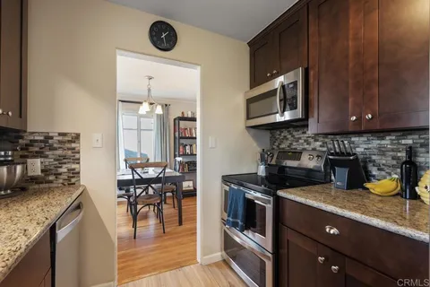 a kitchen with stainless steel appliances granite countertop a refrigerator a stove and a sink with granite countertops