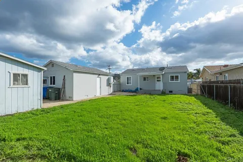 a white house with a small yard and a large space