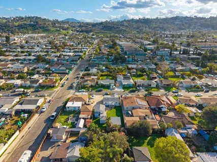 an aerial view of residential houses with outdoor space and mountains