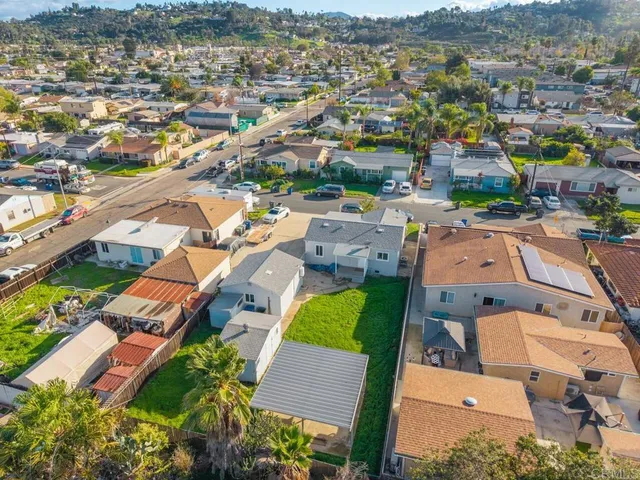 an aerial view of residential houses with outdoor space and mountains