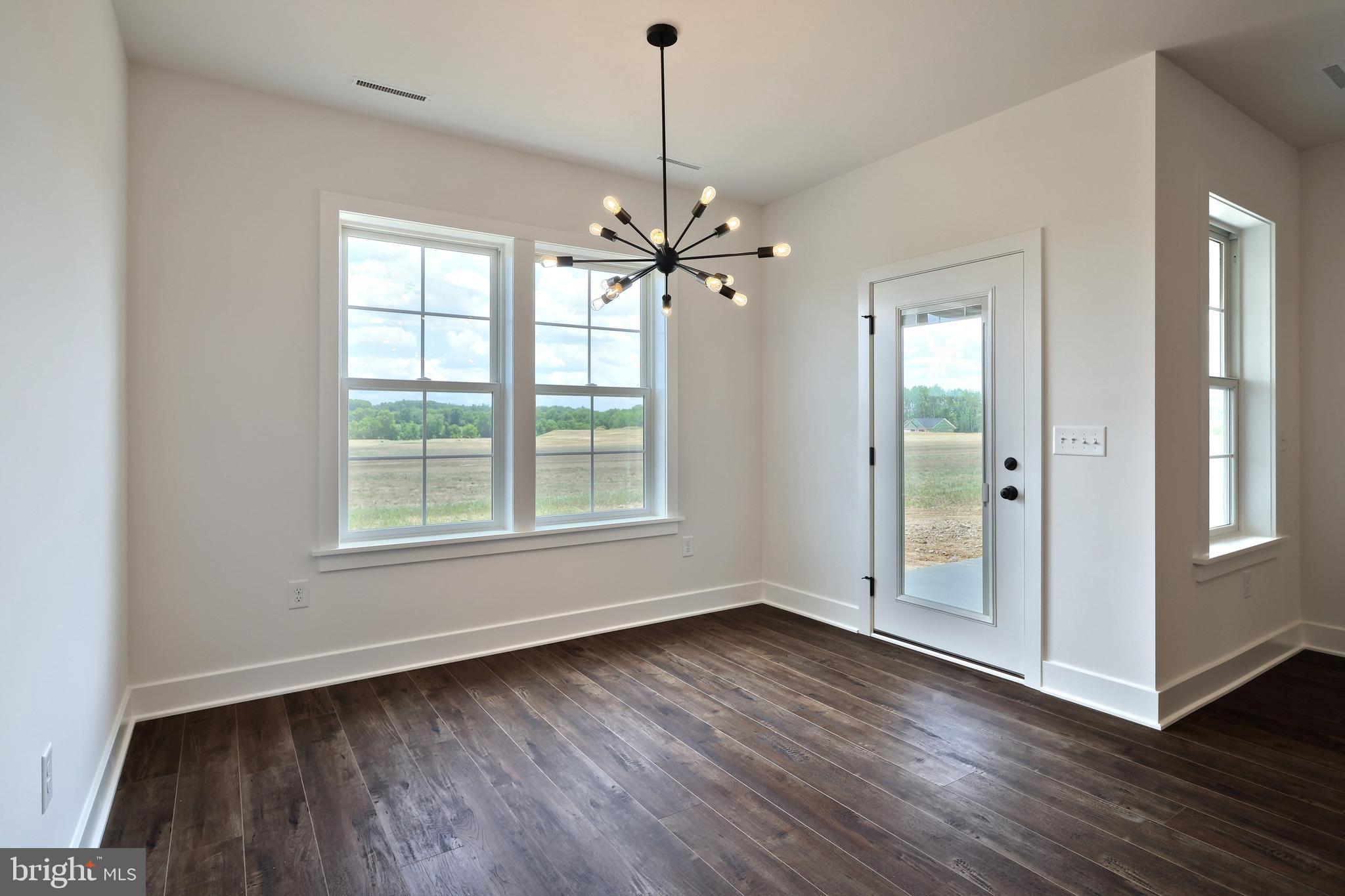 559 Lumber Street Littlestown, PA 17340 - Photo 19 of 73 an empty room with wooden floor chandelier fan and windows