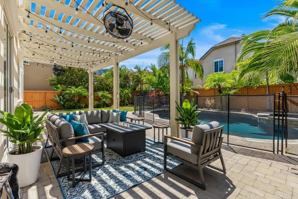 a view of a patio with couches table and chairs potted plants and palm tree