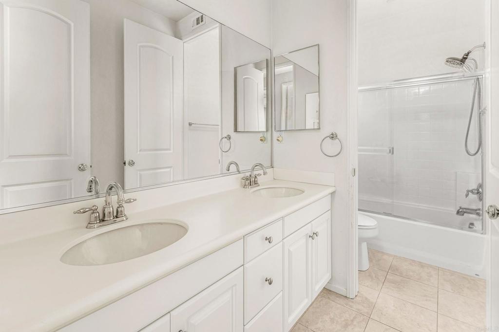 3848 Lake Park Street Fallbrook, CA 92028 - Photo 20 of 35 a bathroom with a sink double vanity granite tub shower and a mirror
