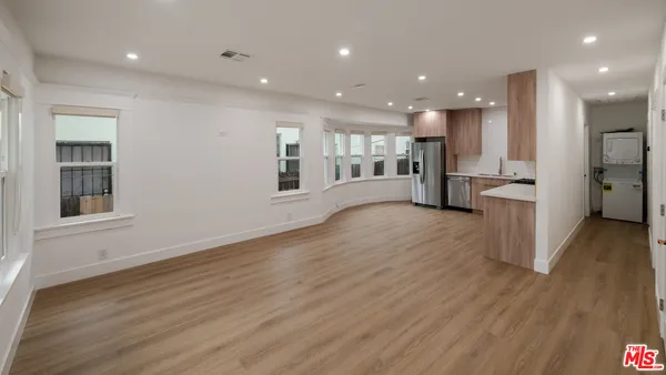 a view of a kitchen with refrigerator and wooden floor