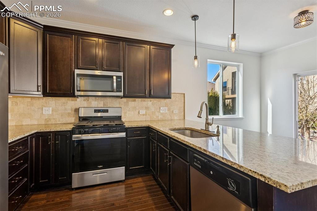 960 Fire Rock Place Colorado Springs, CO 80921 - Photo 9 of 30 a kitchen with a sink stove and microwave