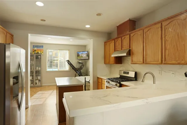 a kitchen with stainless steel appliances a sink a stove and a refrigerator