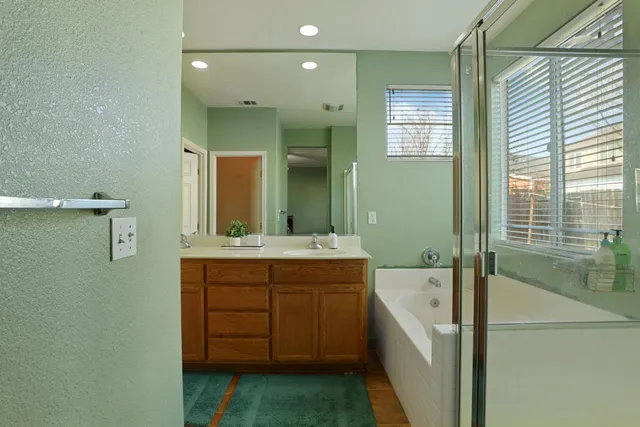 a bathroom with a tub sink and mirror