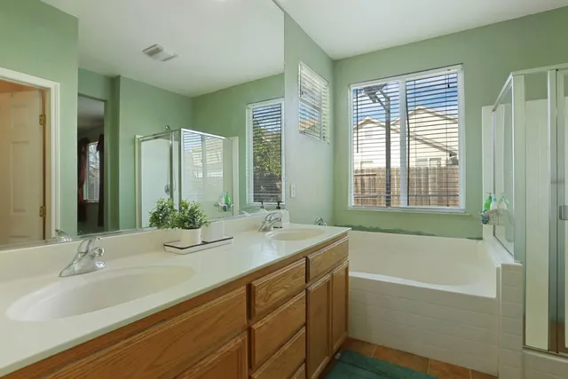a bathroom with a granite countertop tub sink and mirror