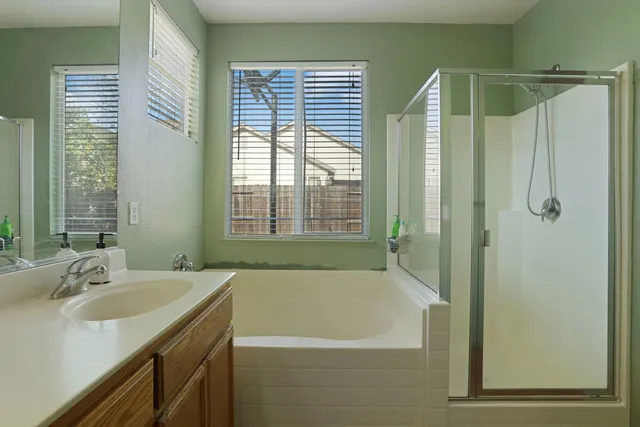 a bathroom with a tub sink and mirror