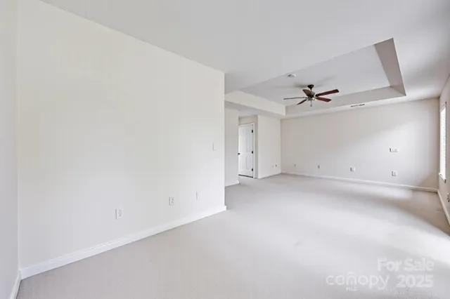 an empty room with a ceiling fan and window