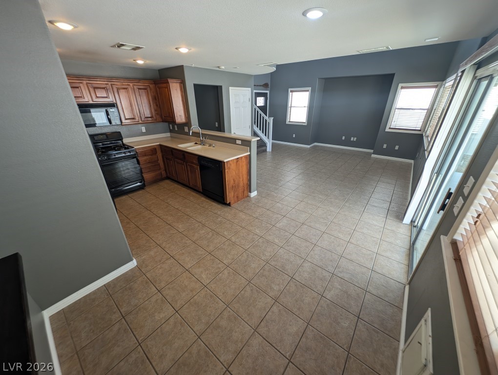 9121 Spoonbill Ridge Place Las Vegas, NV 89143 - Photo 5 of 26 An open-concept living area offers seamless flow between the kitchen and living spaces, illuminated by recessed lighting.