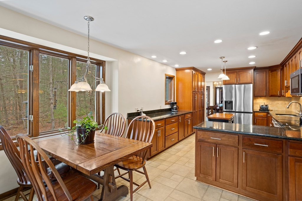 88 Coventry Wood Road Bolton, MA 01740 - Photo 13 of 41 a kitchen with stainless steel appliances granite countertop sink table and chairs