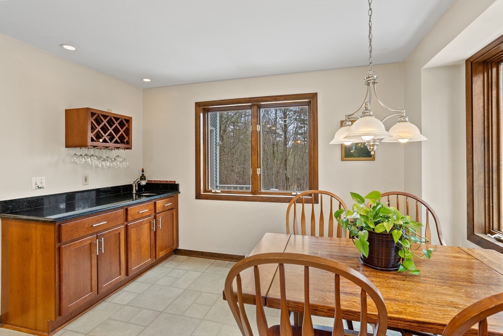 88 Coventry Wood Road Bolton, MA 01740 - Photo 14 of 41 a kitchen with stainless steel appliances granite countertop a stove a sink and a dining table with white cabinet