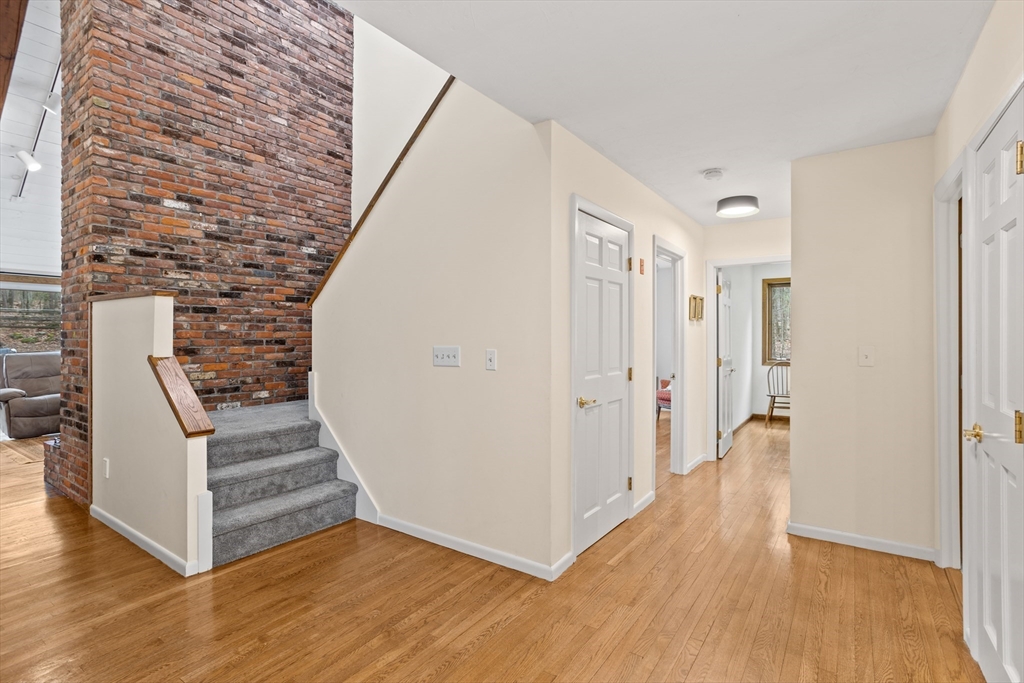 88 Coventry Wood Road Bolton, MA 01740 - Photo 15 of 41 a view of a hallway with wooden floors and stairs