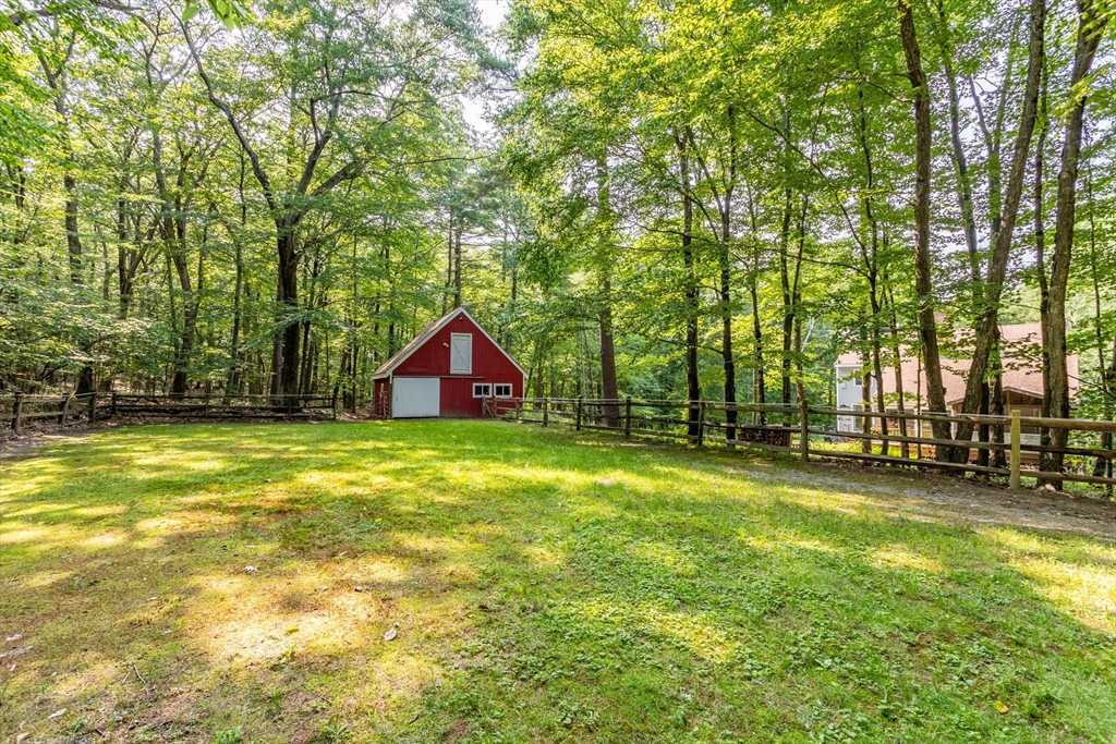 88 Coventry Wood Road Bolton, MA 01740 - Photo 35 of 41 a backyard of a house with lots of green space and fountain