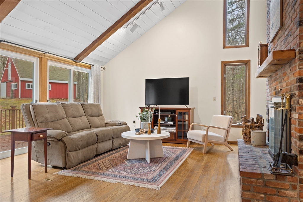 88 Coventry Wood Road Bolton, MA 01740 - Photo 4 of 41 a living room with furniture a flat screen tv and a fireplace