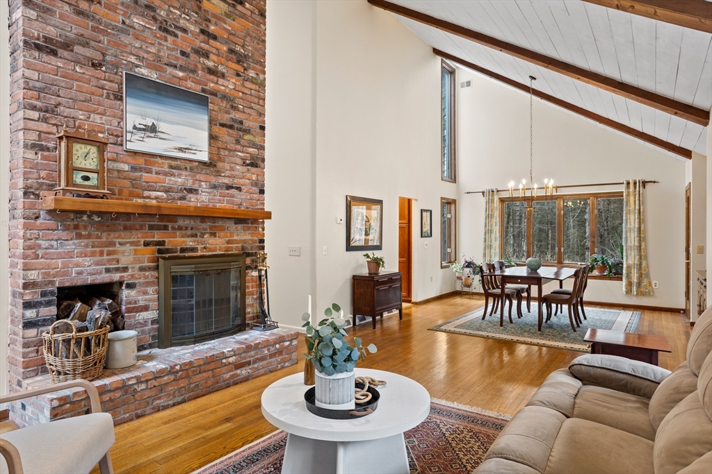 88 Coventry Wood Road Bolton, MA 01740 - Photo 6 of 41 a living room with furniture a fireplace and large windows