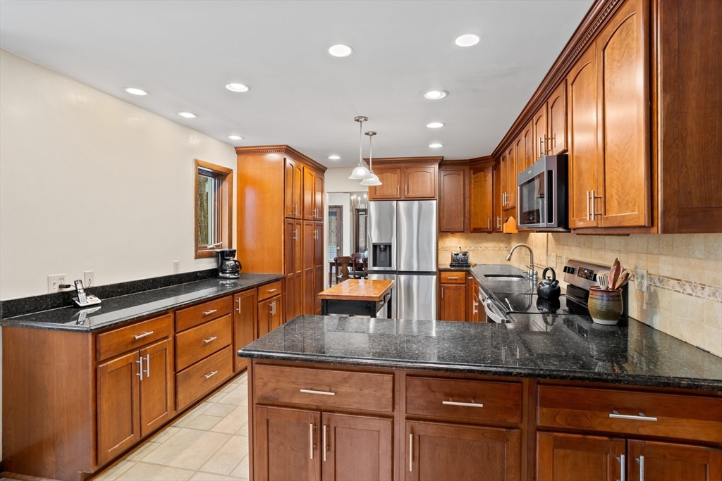 88 Coventry Wood Road Bolton, MA 01740 - Photo 10 of 41 a kitchen with granite countertop a sink a counter space cabinets and stainless steel appliances