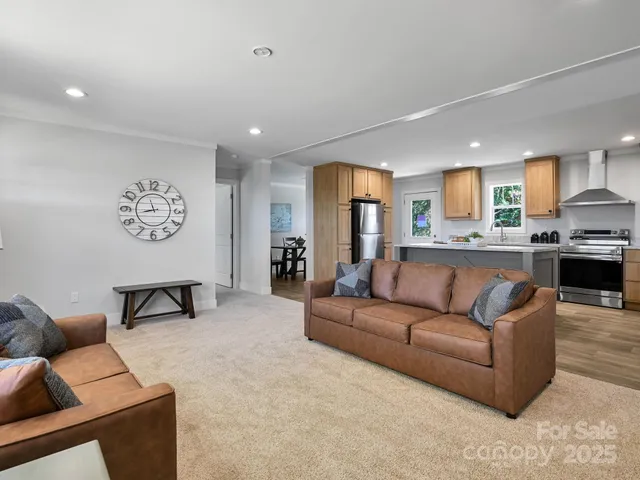 a living room with furniture and a view of kitchen