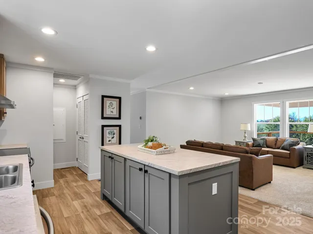 a kitchen that has a sink and chairs in it