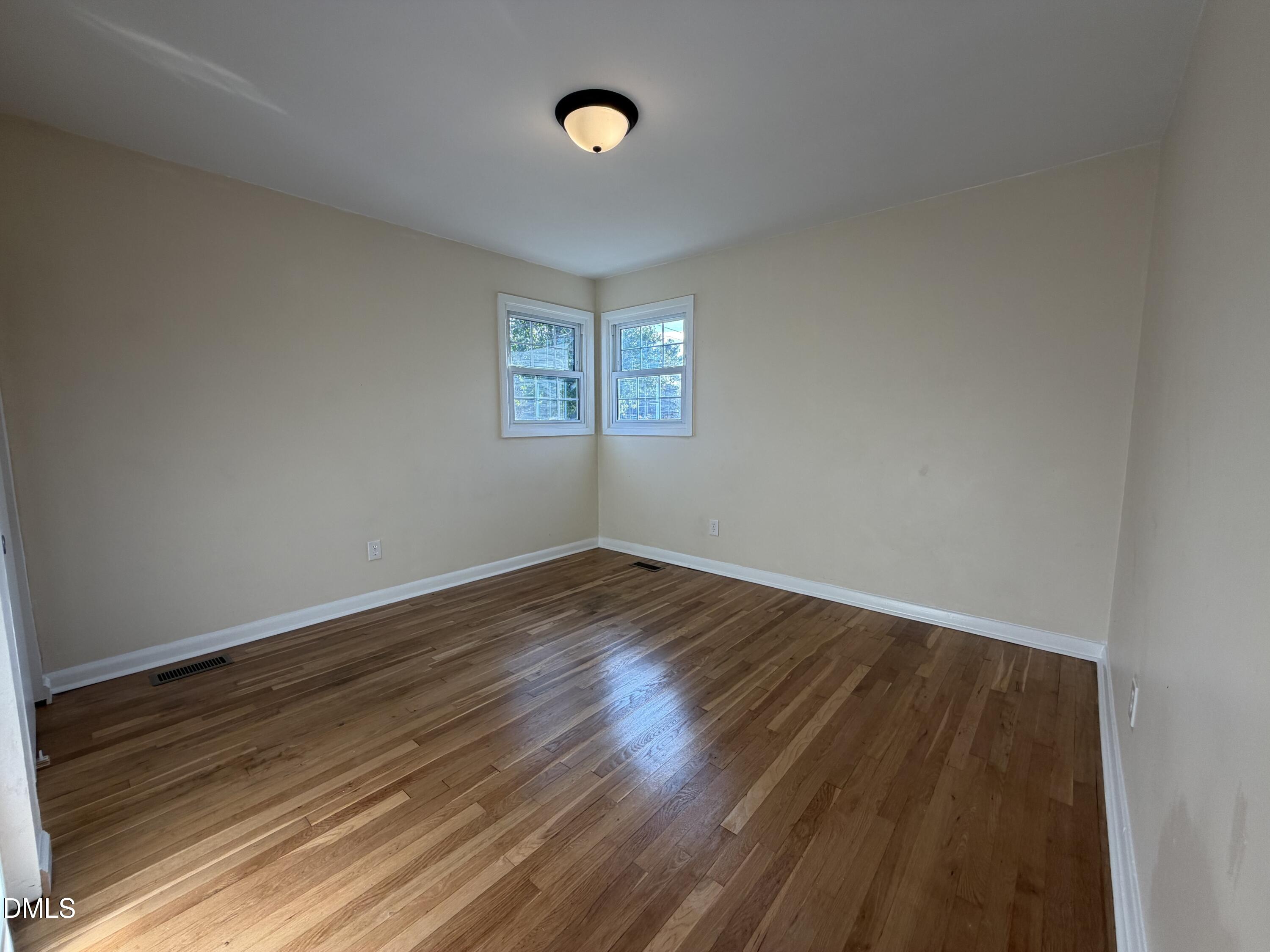 503 Spring Avenue Spring Lake, NC 28390 - Photo 22 of 36 a view of an empty room with wooden floor and a window