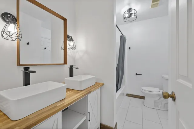 a bathroom with a sink a toilet and mirror