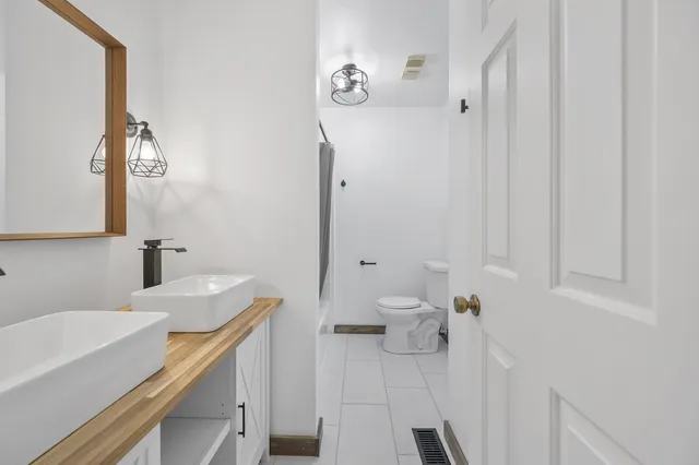 a bathroom with a sink vanity granite and toilet