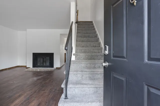 a view of an entryway with wooden floor and a fireplace