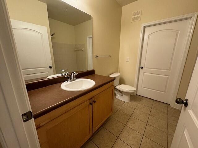 6441 Borasco Drive, Unit 2404 Melbourne, FL 32940 - Photo 11 of 28 a bathroom with a sink a toilet a mirror and vanity