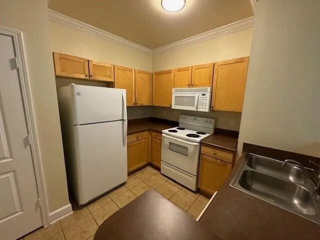 a kitchen with a refrigerator sink stove and cabinets