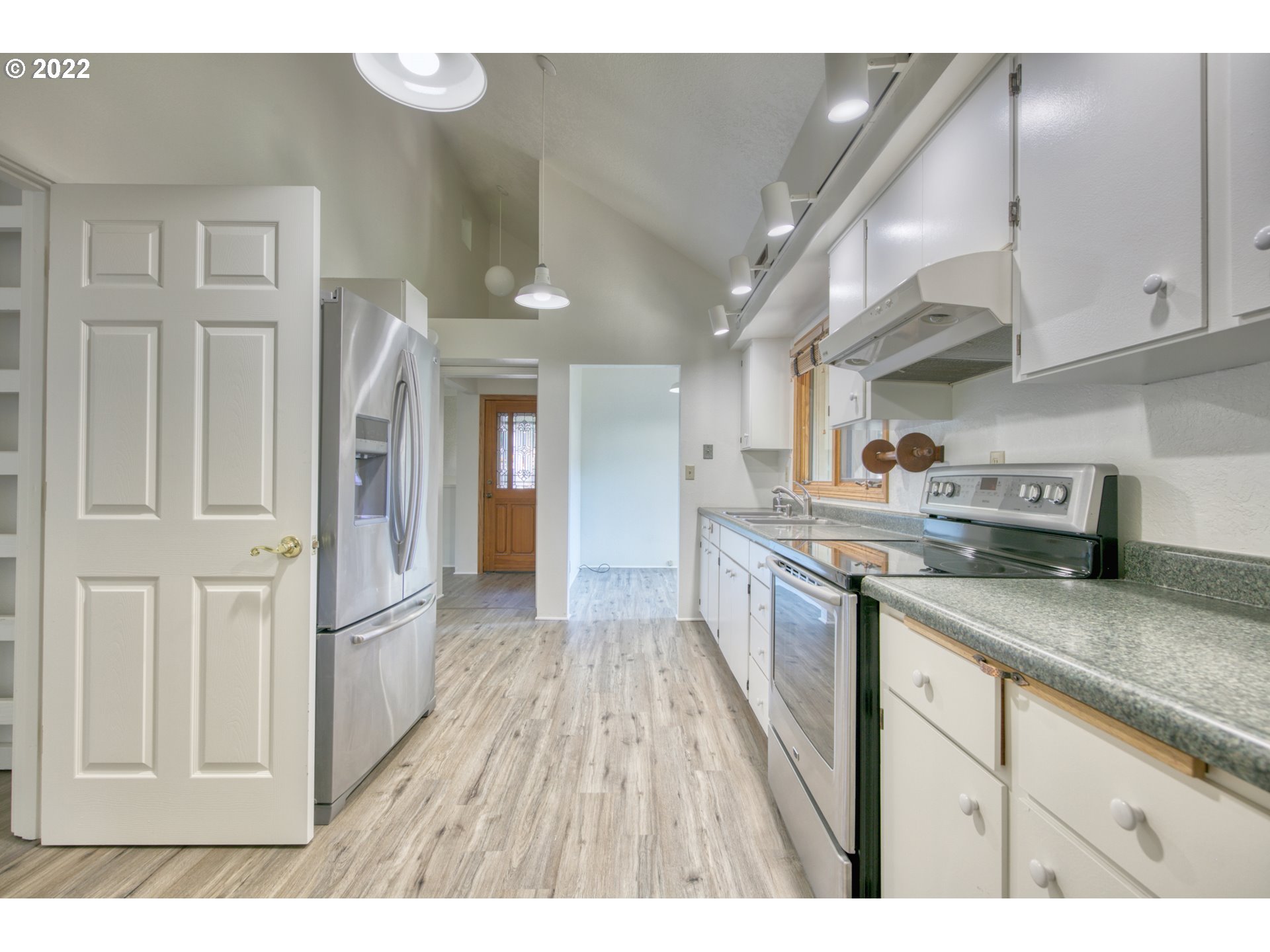 37821 Shenandoah Loop Springfield, OR 97478 - Photo 7 of 32 a kitchen with stainless steel appliances granite countertop a refrigerator a sink dishwasher and wooden cabinets with wooden floor
