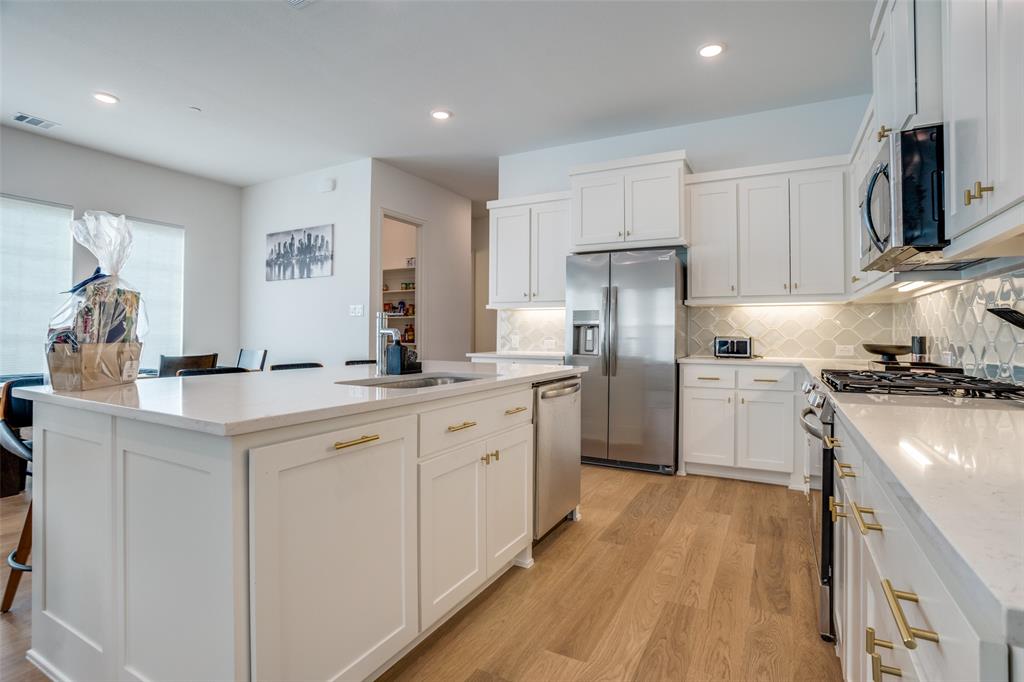 15603 Palmwood Road Frisco, TX 75033 - Photo 6 of 12 a kitchen with white cabinets appliances and sink