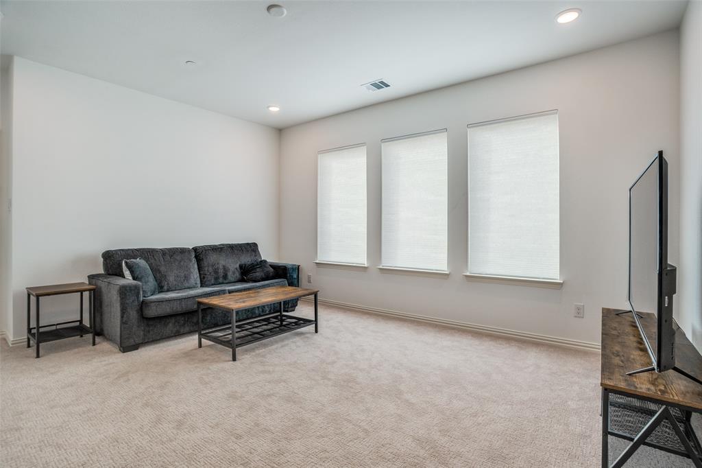 15603 Palmwood Road Frisco, TX 75033 - Photo 7 of 12 a living room with furniture a flat screen tv and a window