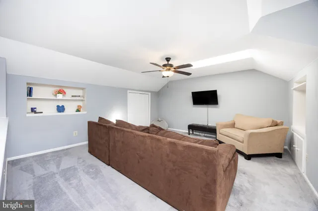a living room with furniture and a ceiling fan