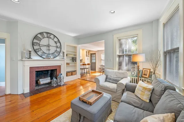 a living room with furniture a fireplace and a large window