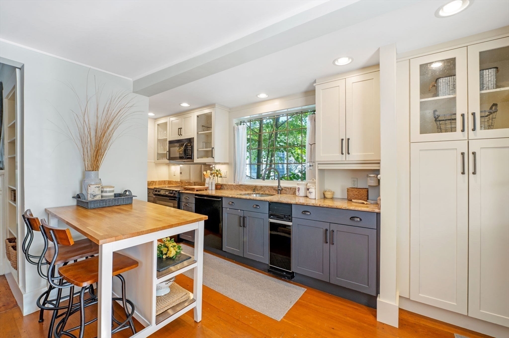 29 Front Street, Unit 2 Marblehead, MA 01945 - Photo 10 of 38 a kitchen with stainless steel appliances granite countertop a stove a sink dishwasher and a refrigerator with wooden floor