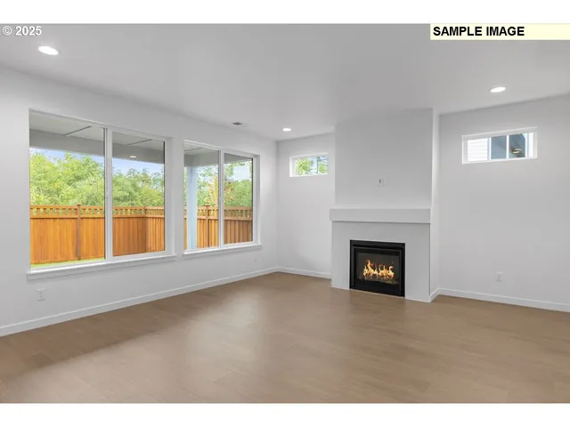 a view of an empty room with a fireplace and a window