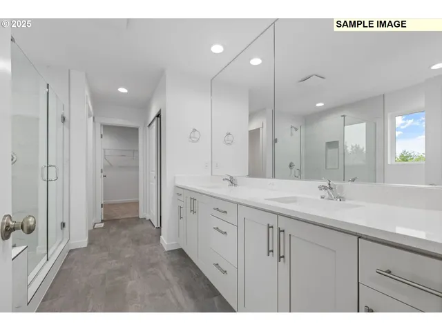 a spacious bathroom with a double vanity sink a large mirror and shower