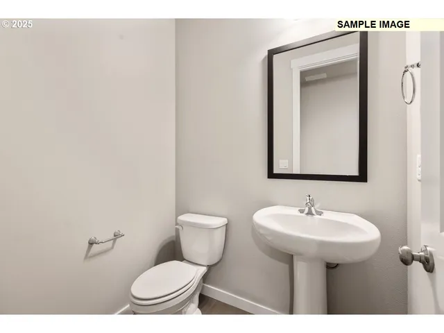 a view of an empty room with wooden floor fire place and a window