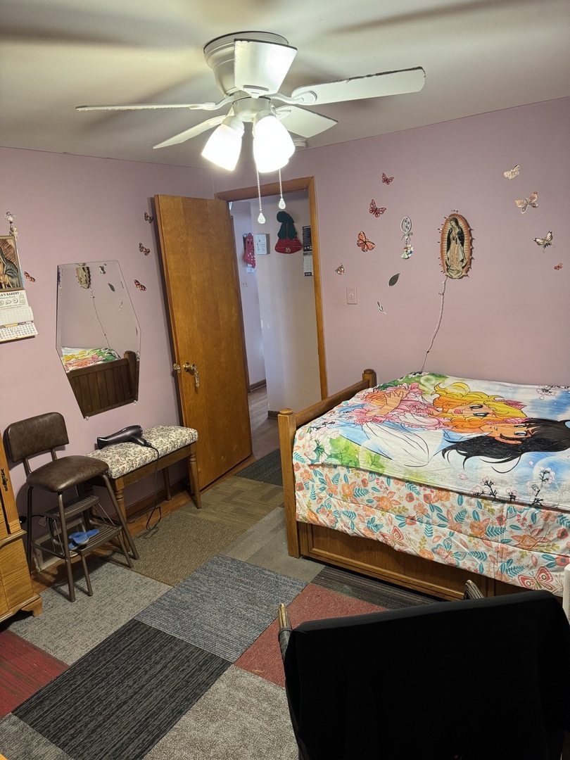 7836 Monitor Avenue Burbank, IL 60459 - Photo 15 of 26 a bedroom with a bed and a chandelier