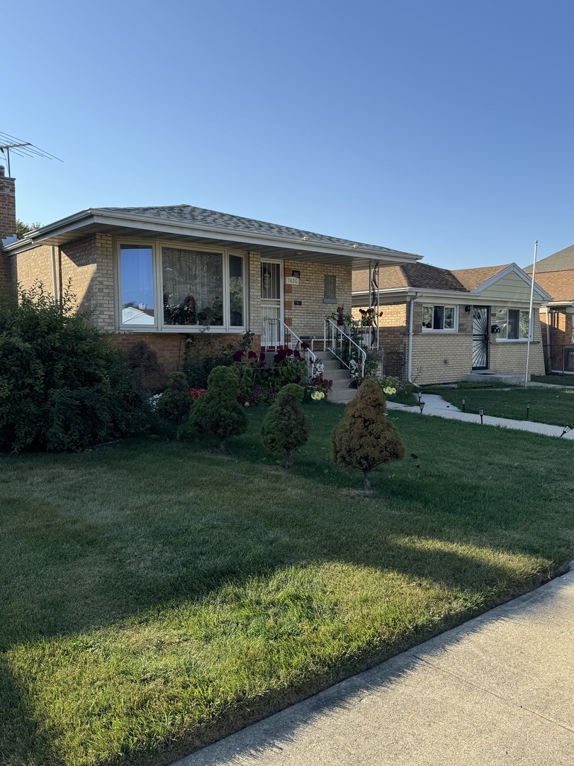 7836 Monitor Avenue Burbank, IL 60459 - Photo 25 of 26 a front view of a house with a garden and yard