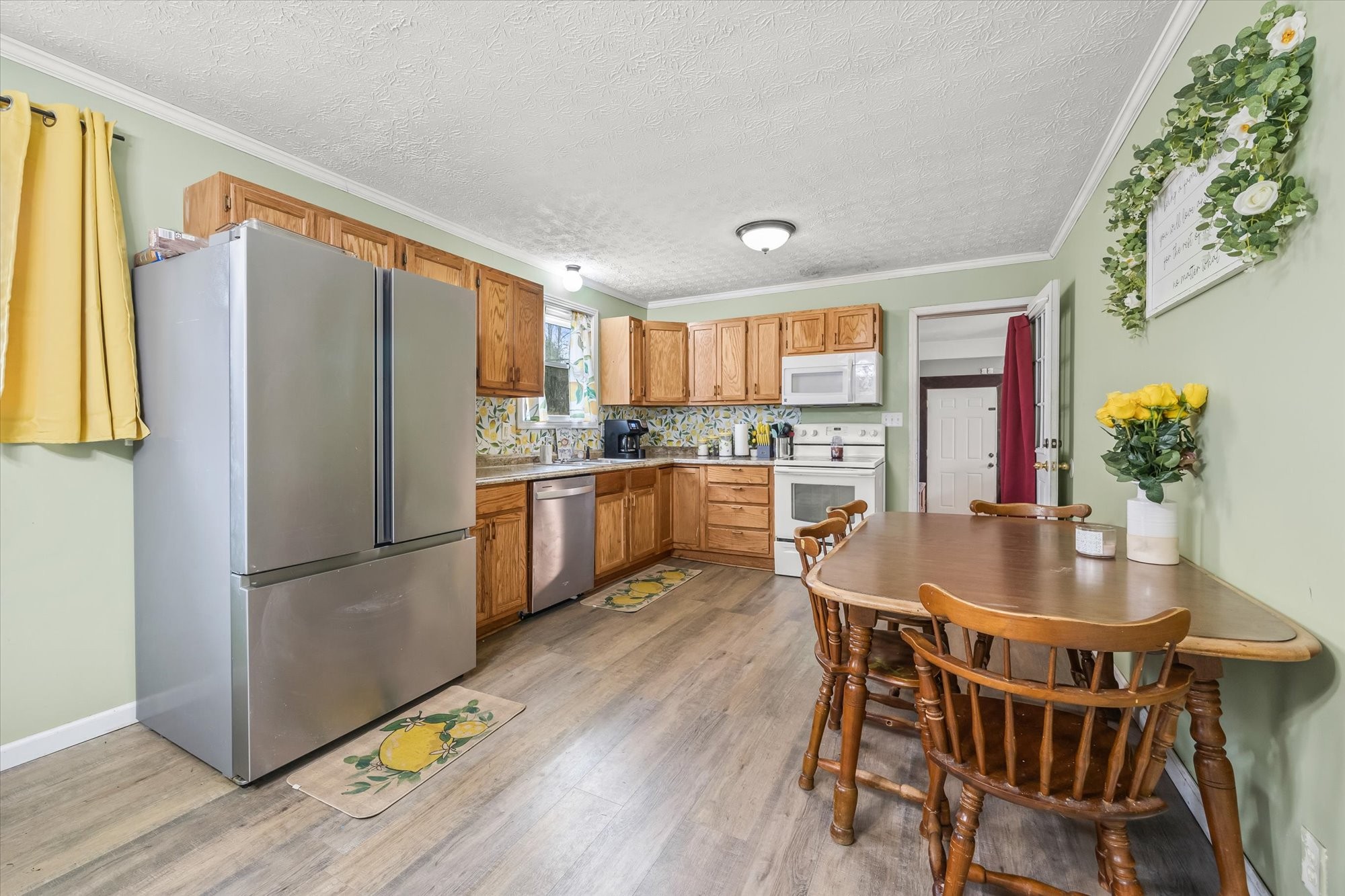 7939 Old Baxter Road Baxter, TN 38544 - Photo 4 of 23 a kitchen with stainless steel appliances a dining table chairs refrigerator and cabinets