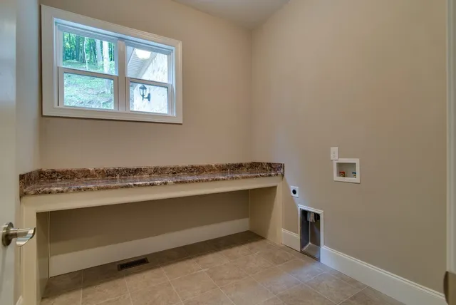 a spacious bedroom with a bed and a chandelier