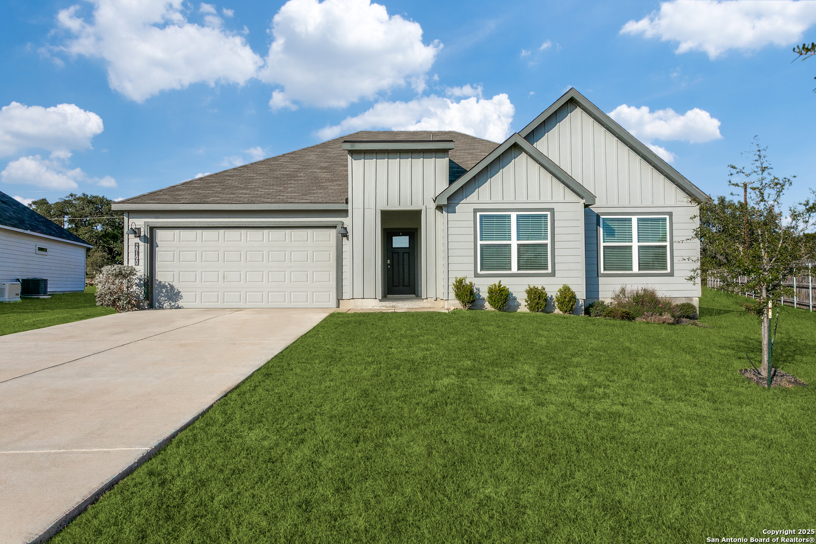 a view of a house with a yard and large tree